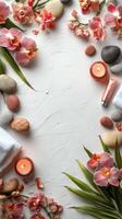 A serene spa setting with flowers, stones, and candles on a calming white surface photo