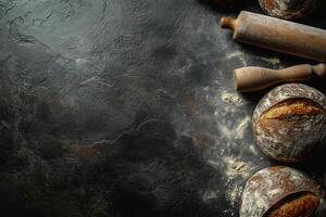 Freshly baked bread and kitchen tools on a dark countertop ready for baking at home photo