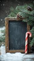 A rustic chalkboard adorned with a candy cane and snow during winter festivities outdoors photo