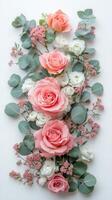 Elegant arrangement of pink and white roses with greenery on a light background photo