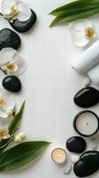 A serene spa setting with flowers, stones, and candles on a calming white surface photo