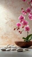 Delicate pink orchids floating above a wooden bowl with white stones on a soft background photo