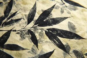 Subtle shadows cast by bamboo leaves on textured white paper in natural light photo