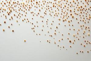 A multitude of golden stars scattered across a white background for creative decoration photo