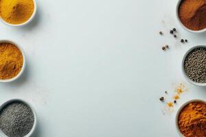 Colorful arrangement of various spices and herbs on a white surface with empty space for text photo