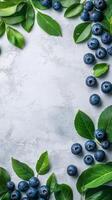 Fresh blueberries surrounded by green leaves arranged on a light background for a natural display photo