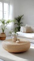 A cozy living room with natural decor featuring a round woven coffee table and indoor plants photo