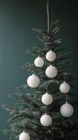 Decorated Christmas tree with white ornaments on a green background in winter celebration photo