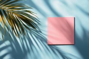 Colorful square canvas against a bright blue wall with palm shadows in a sunny environment photo