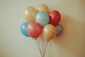 Colorful balloons resting against a white wall on a bright sunny day in an urban area photo