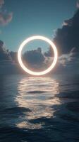 A bright circular light glowing through dramatic clouds over a calm ocean at dusk photo