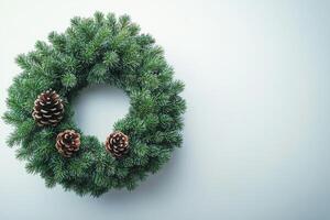 Green pine wreath with a single pine cone on a neutral background during the winter season photo
