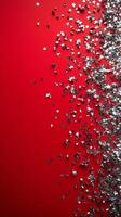 Shimmering silver confetti scattered on vivid red background for festive celebrations photo