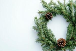 Green pine wreath with a single pine cone on a neutral background during the winter season photo