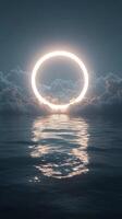 A bright circular light glowing through dramatic clouds over a calm ocean at dusk photo