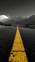A winding road leads through mountain passes under a dramatic cloudy sky in a remote landscape photo