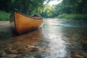 A peaceful canoe rests by the clear waters of a calm river at sunset photo