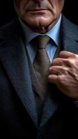Man in a tailored suit poses confidently against a dark background in a stylish indoor setting photo