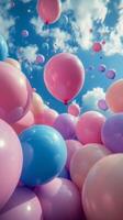 Colorful balloons and bubbles float in a clear blue sky during a sunny day photo