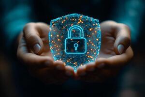 Hands holding a glowing digital shield representing cybersecurity in a modern setting photo