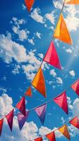 Colorful flags sway under a bright blue sky filled with clouds during a sunny day of celebration photo