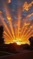 Beautiful sunset with vibrant clouds and rays illuminating a quiet suburban street photo