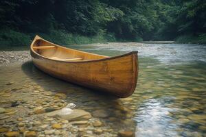 A peaceful canoe rests by the clear waters of a calm river at sunset photo