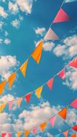 Colorful flags sway under a bright blue sky filled with clouds during a sunny day of celebration photo