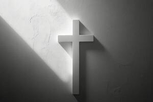 A white cross casting shadows on a textured wall in soft light during the early morning hours photo