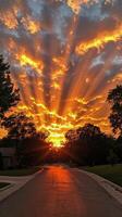 Beautiful sunset with vibrant clouds and rays illuminating a quiet suburban street photo