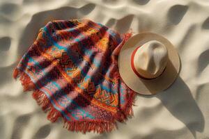 Colorful blanket and straw hat on sandy beach at sunset showcasing vibrant patterns and textures photo