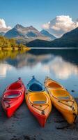 Brightly colored kayaks lined up along a serene lakeshore under a vibrant sky at sunset photo
