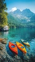 Colorful kayaks resting on a clear lake surrounded by mountains and lush greenery during daylight photo