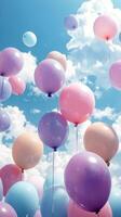 Colorful balloons and bubbles float in a clear blue sky during a sunny day photo