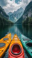 Colorful kayaks float gently on serene water amidst majestic mountains and lush forests in summer photo