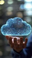 A person holds a glowing cloud symbol representing digital storage and technology indoors photo