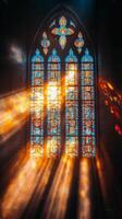 Sunlight streaming through stained glass windows in an ancient church during early morning hours photo