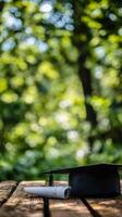 Black yoga mat rolled up on a wooden surface in a serene green outdoor environment during daytime photo