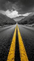 A winding road leads through mountain passes under a dramatic cloudy sky in a remote landscape photo