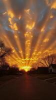 Beautiful sunset with vibrant clouds and rays illuminating a quiet suburban street photo