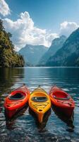 Colorful kayaks float gently on serene water amidst majestic mountains and lush forests in summer photo