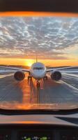 Airplane at the gate during a vibrant sunset at the airport with dramatic clouds above photo