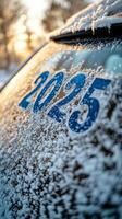 Snow covered vehicle displaying the year 2025 during a winter morning in a rural area photo