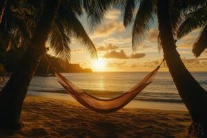 Tranquil hammock resting between palm trees on a serene beach during sunset photo