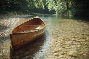 A peaceful canoe rests by the clear waters of a calm river at sunset photo