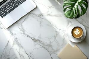 A cozy coffee break with latte art beside a laptop on a marble table in a modern workspace photo