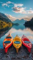 Brightly colored kayaks lined up along a serene lakeshore under a vibrant sky at sunset photo