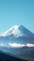 Snow capped mountain under a clear blue sky with fluffy clouds in the foreground during daytime photo