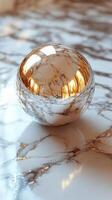 Elegant marble sphere resting on a polished surface with golden veins and reflections photo