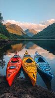 Brightly colored kayaks lined up along a serene lakeshore under a vibrant sky at sunset photo